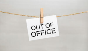 A sign saying out of office is pegged onto a string