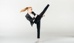 woman high kicking dressed in a suit