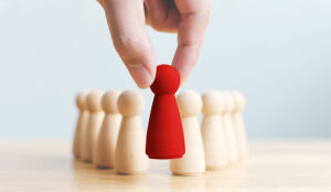 A photo of a red chess pawn being put into place