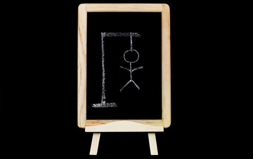 A blackboard has a hangman drawn written in white chalk