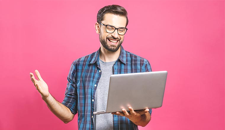 A photo of someone stood up at a laptop