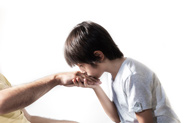 A child kisses the back of a grandparents hand