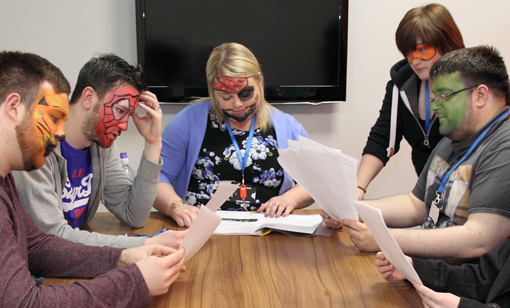 Members of the team with their face painted attend a meeting