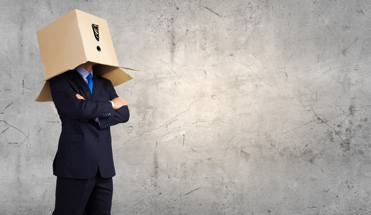 A man has a cardboard box on his head, with an exclamation mark drawn on it