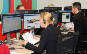 A back view of a lady answering a call, wearing a smart black suit