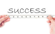 A ruler is held up to the word success