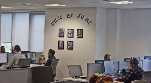 The wall of the contact centre displays a 'wall of fame' where pictures of the advisors who have been recognised are displayed. 