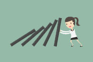 A cartoon propping up a stack of dominoes
