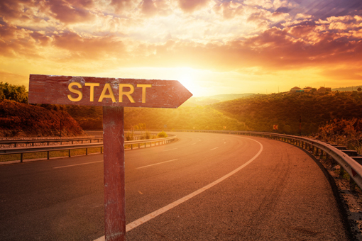 A sign post indicating the start, at the top of a road. 