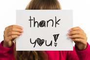 A child holds up a sign saying thank you