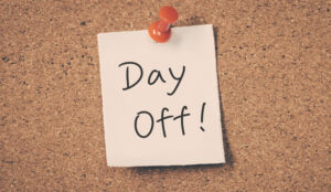 A post it note attached to a cork board saying day off!