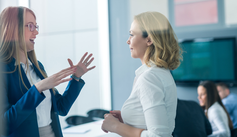 A young woman speaks animatedly to an older supervisor