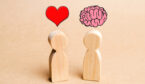 Two wooden dolls, one with a heart above it, the other with a brain