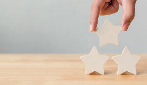 Hand putting wooden five star shape on table.