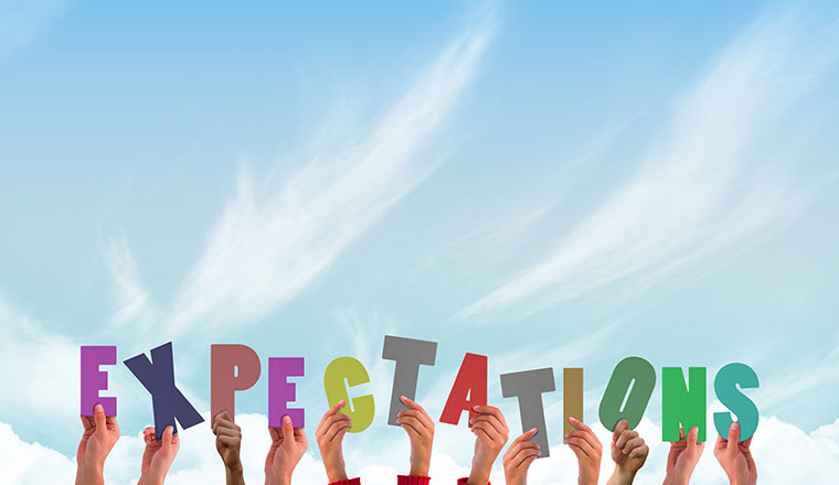 People hold up letters spelling out expectations