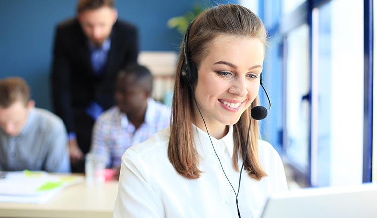 Portrait of call center worker accompanied by her team.