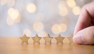 Hand putting wooden five star shape on table.