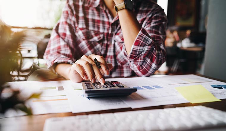 Businessman working on calculator to calculate business data the financial report. Business financial analysis and strategy concept.