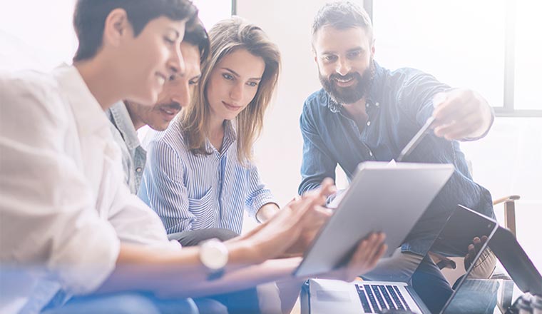 Group of young coworkers discussing ideas with each other in modern office.