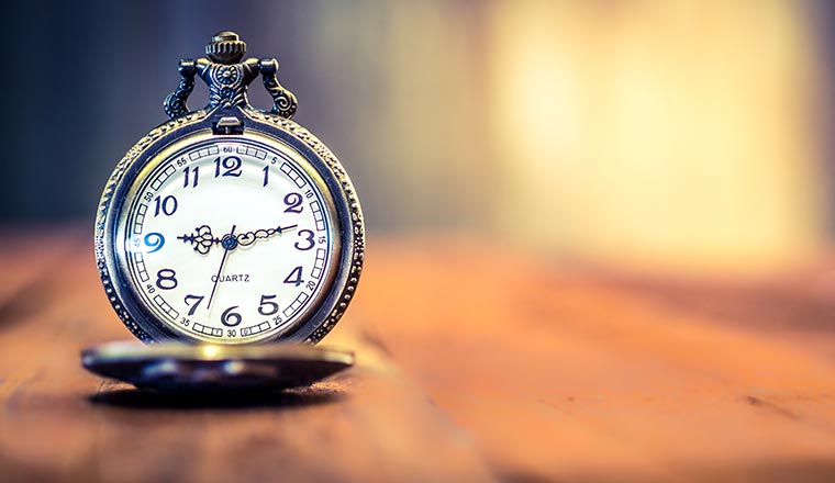 old antique pocket watch showing time on wooden floor with blurr