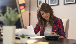 Woman using a calculator, making calculations and checking business statistics