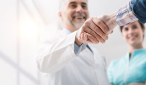 Doctor and female patient meeting at the hospital and shaking hands
