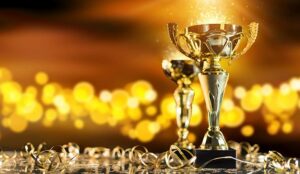 Champion golden trophy on wood table with blur spot lights on background.