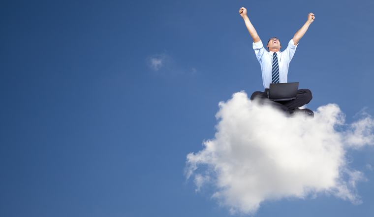 A happy man with a laptop is sat on top of a fluffy cloud