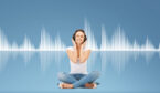 A woman listens to headphones, with sound waves in the background