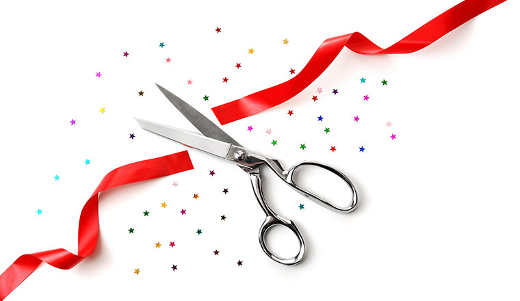 Grand Opening illustrated with a scissors, a red ribbon and confetti on a white background