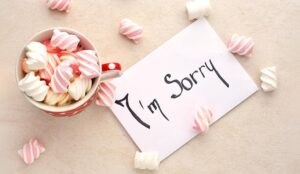 A note with I'm sorry, and marshmallows on a light