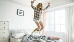 Caucasian girl jumping on bed