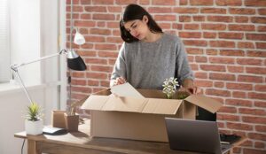 Sad Fired Young Employee Packing A Box To Leave The Office