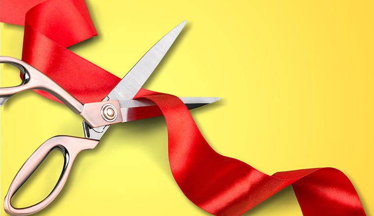 Scissors cutting red ribbon