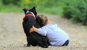 A photo of a child hugging a dog