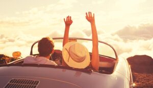 Happy Young Couple Enjoying the Sunset in Classic Vintage Sports Car