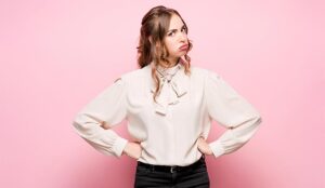 A photo of a frustrated young business woman on pink studio background