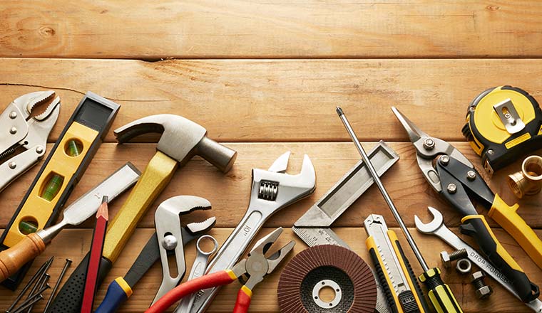 A photo of a variety of tools on wood planks