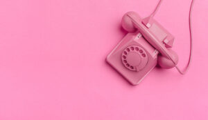 A photo of an old phone against a pink background