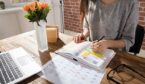 A photo Businesswoman Making Agenda On Personal Organiser At Workplace