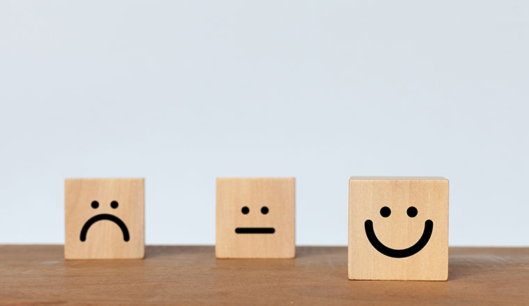 Smiley face wood cube on white background.