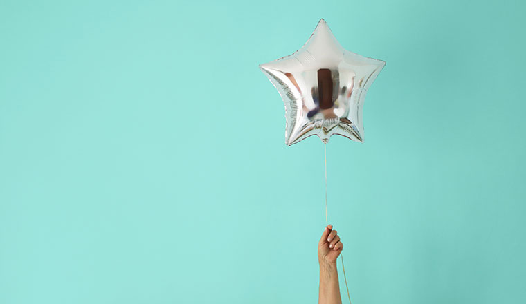 A picture of someone holding a balloon shaped like a star