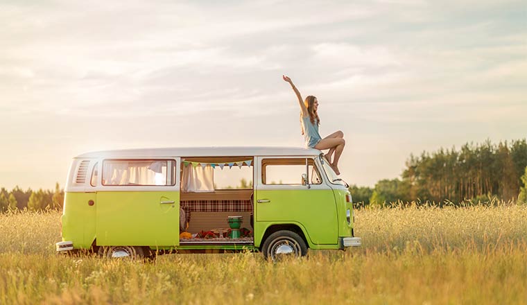 A photo of a person sat on top of a camper van