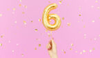A photograph of a woman's hand holding a balloon