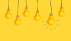 A picture of many hanging light bulbs on a yellow background