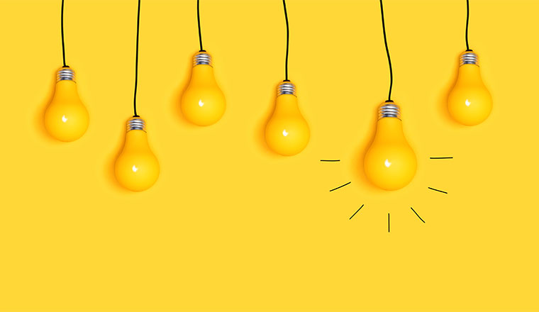 A picture of many hanging light bulbs on a yellow background