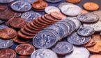 A photo of American coins and us dollars on a black table