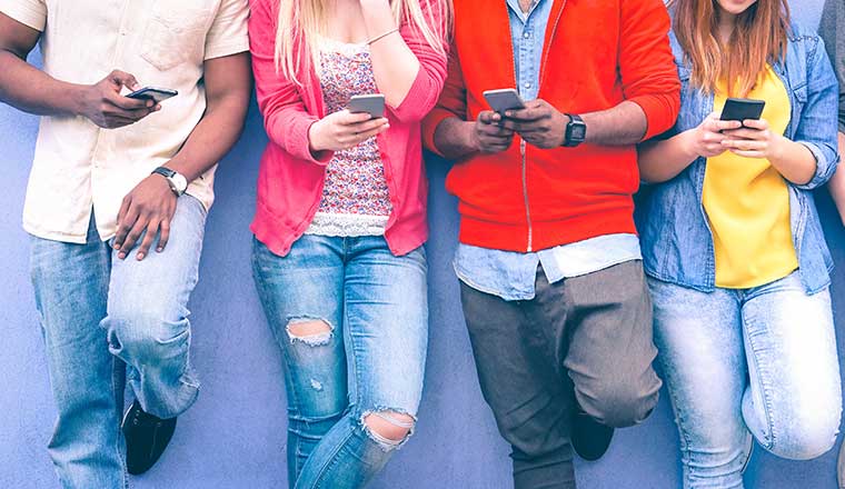 A photo of a line of people all on their phones