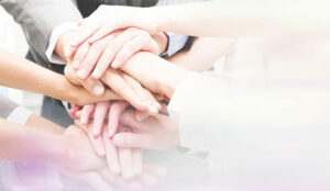 A photo of a circle of people all putting their hands together