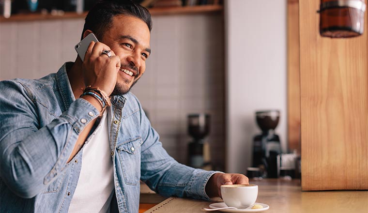 A photo of a man smiling on his phone